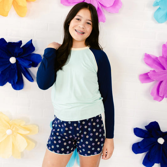Bright flower background with modeling wearing the decidedly unique sleep short set, the decided collection, pajamas and loungewear for tween girls